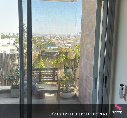 דלת הזזה מזכוכית עם מסגרת אלומיניום ביציאה למרפסת